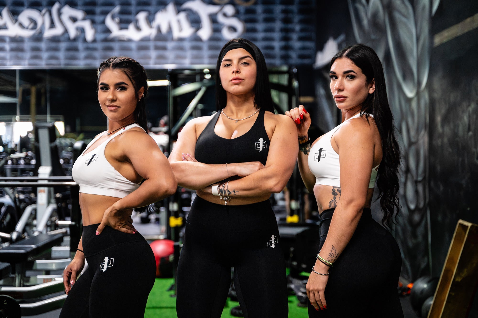 Three fit women in workout clothes at the gym demonstrating the benefits of exercise and healthy eating