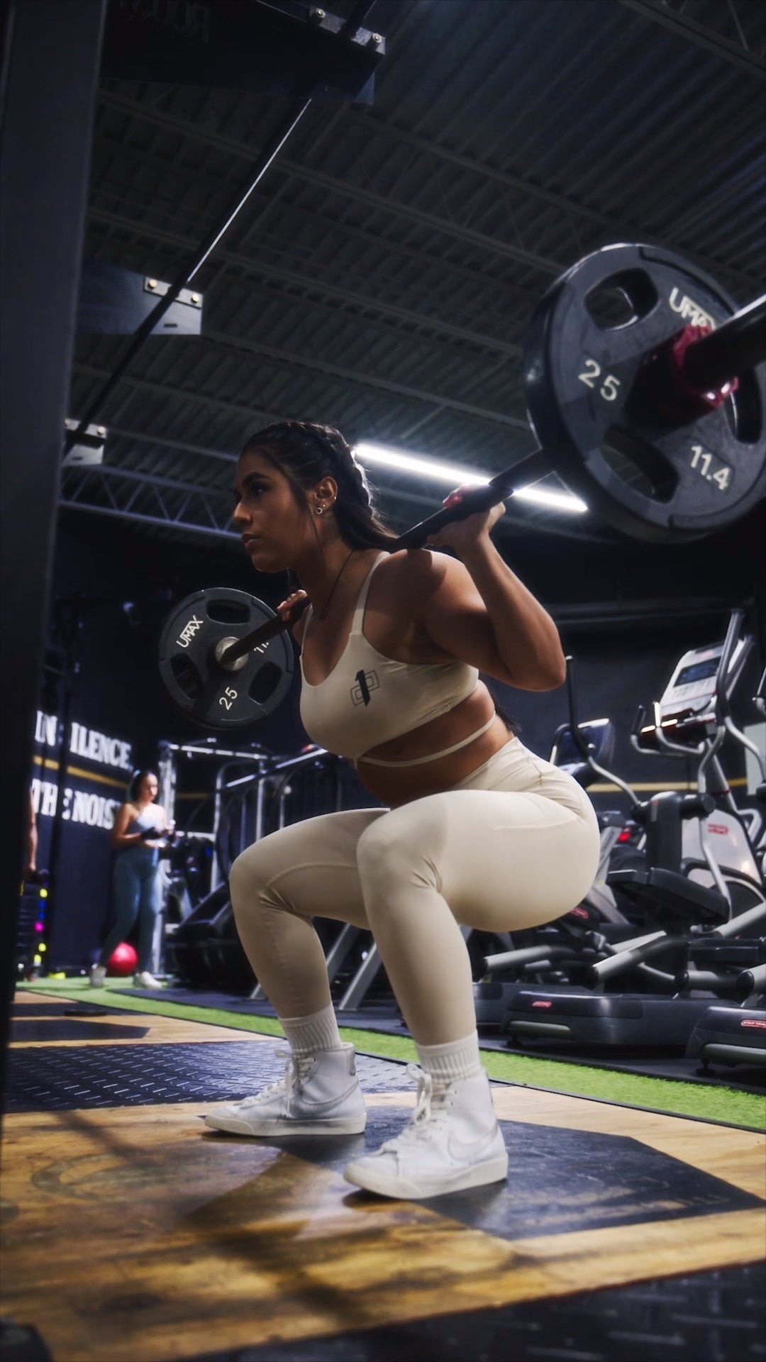 Woman performing weighted squat in gym demonstrating how to master the squat with proper form and technique